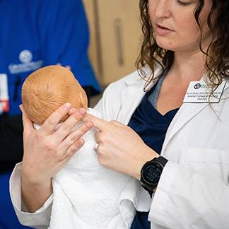 KCON Faculty with an infant manikin